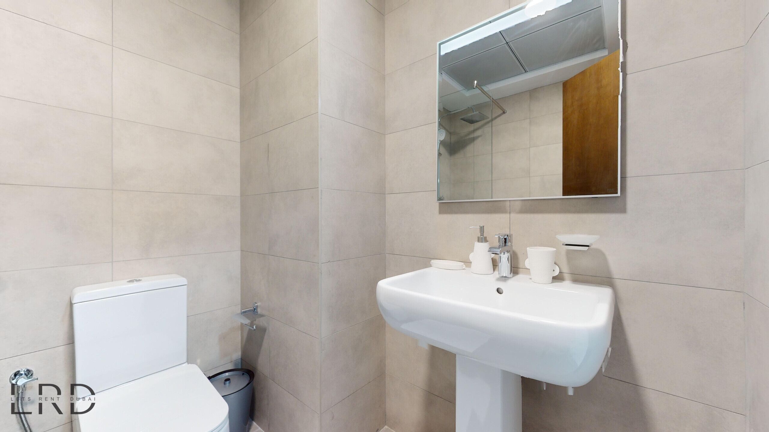 Un bagno con il water, un lavandino e uno specchio.