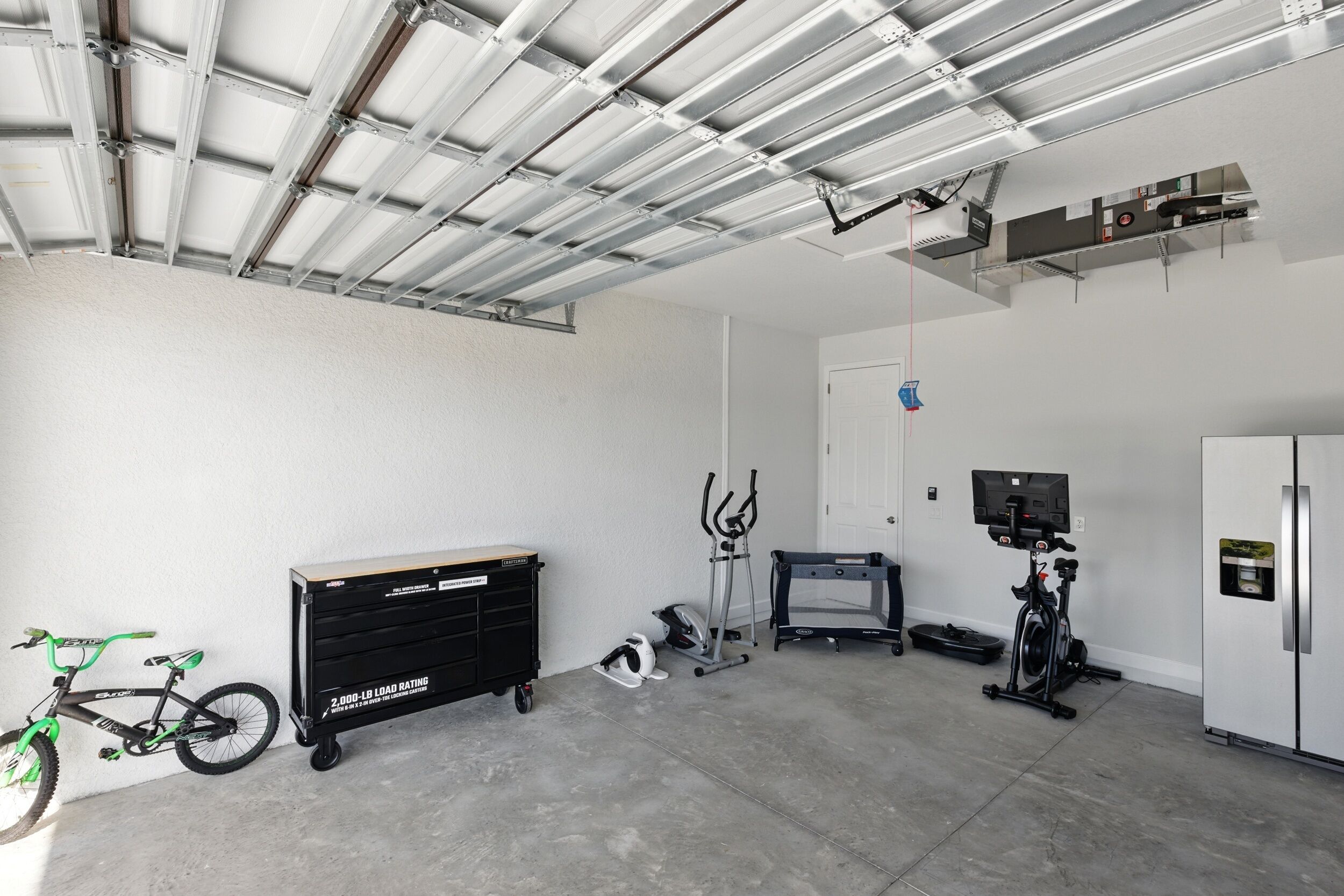 Un gimnasio con equipo de ejercicio, una bicicleta y un armario.