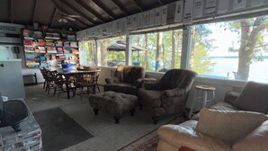 A cozy living room with a fireplace, a dining area, and a view of a lake.