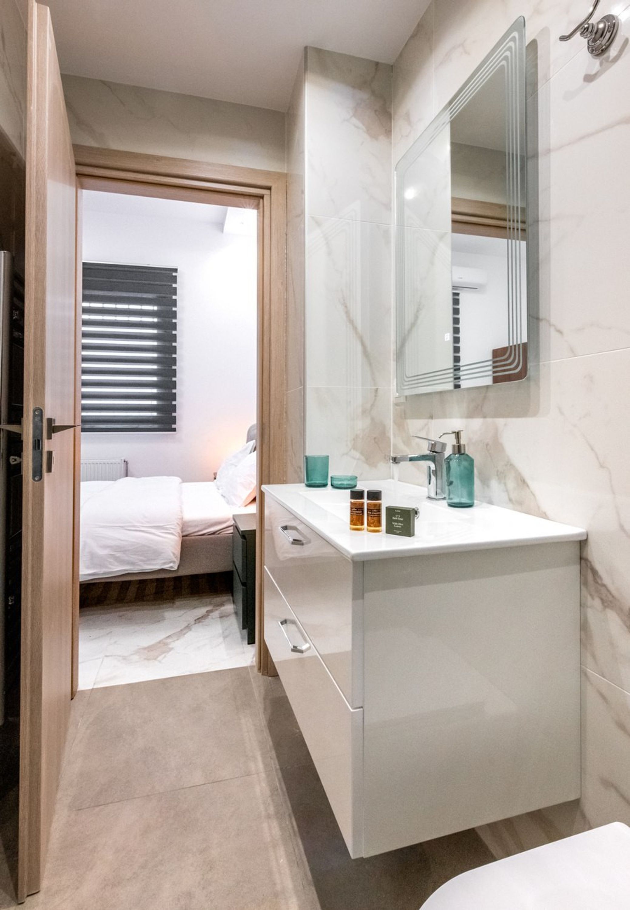 A modern bathroom with a large mirror, a white sink, and a shower area.
