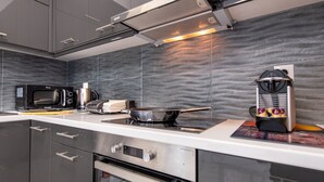 A modern kitchen with stainless steel appliances, a built-in oven, and a microwave. - LIV - Modern Spacious Apartment in Gazi (Athens)