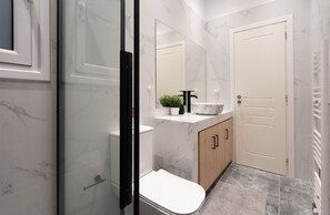Ein modernes Badezimmer mit Toilette, Waschbecken und Spiegel.