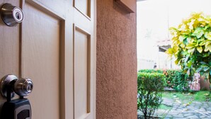 A door with a keypad lock and a wall-mounted intercom. - Villas Paraiso B52 (Jacó)