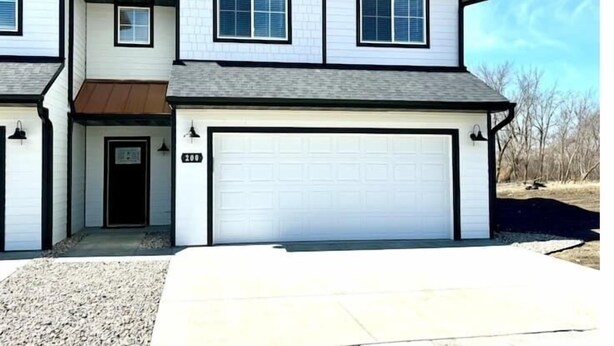 A two-story house with a garage, a front door, and a small porch.