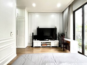 A bedroom with a large bed, a TV, and a window with curtains. - J'adore Garden House - Vinh Yen (Vinh Phuc)