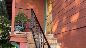 A staircase with a black metal railing leading to a wooden door. - Charming 3 BR Home Near Redwood Park w/ Bay Views (Oakland)