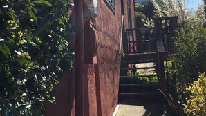Un edificio rojo con una puerta de madera y un dispensador de agua en la pared.