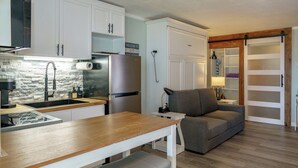 A compact kitchen with white cabinets, a stone backsplash, and a wooden countertop. - Beach Bum Hideaway - Cozy studio condo with full kitchen. 400 ft to the beach! (Hampton)