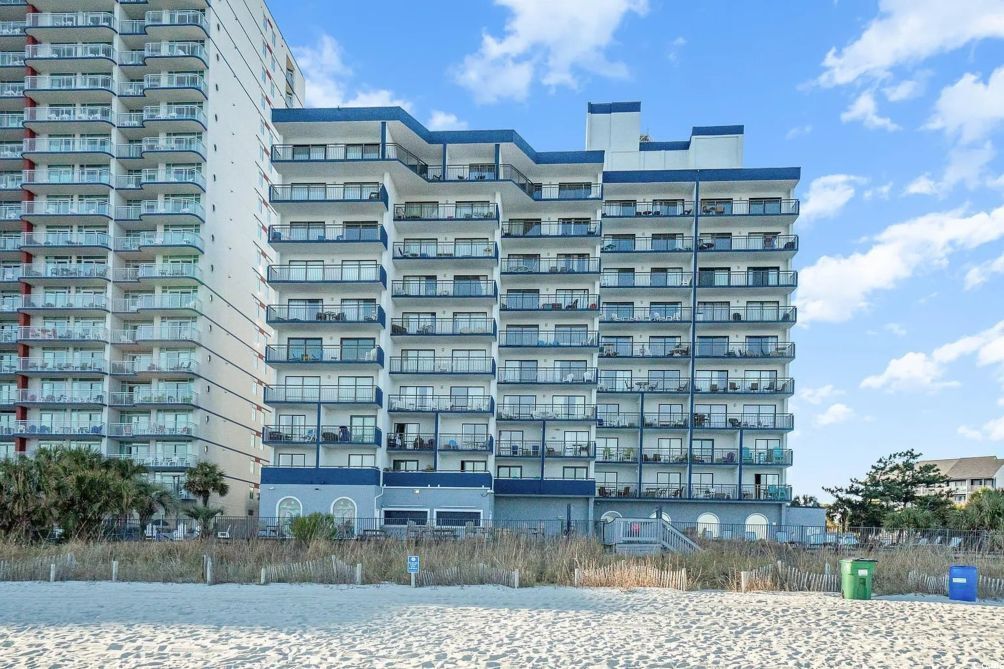 Ein mehrstöckiges Hotel mit Balkonen in Strandnähe.