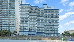 Un hotel de varios pisos con balcones, cerca de una playa.