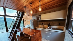 Una cocina moderna con detalles de madera, un refrigerador de acero inoxidable y una cafetera.