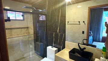 Een moderne badkamer met een douchecabine van glas, een toilet en een wastafel met spiegel.