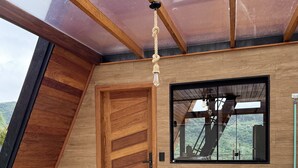 Un interior moderno con una mesa de madera, un ventanal grande y una puerta.
