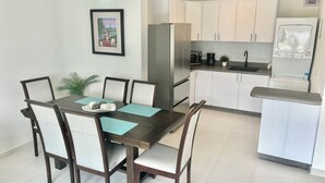 A modern kitchen with white cabinets, a stainless steel refrigerator, a microwave, and a built-in oven. - Modern 1 BR Condo at ISLA VERDE, Free parking, Pool & Wifi (Carolina)