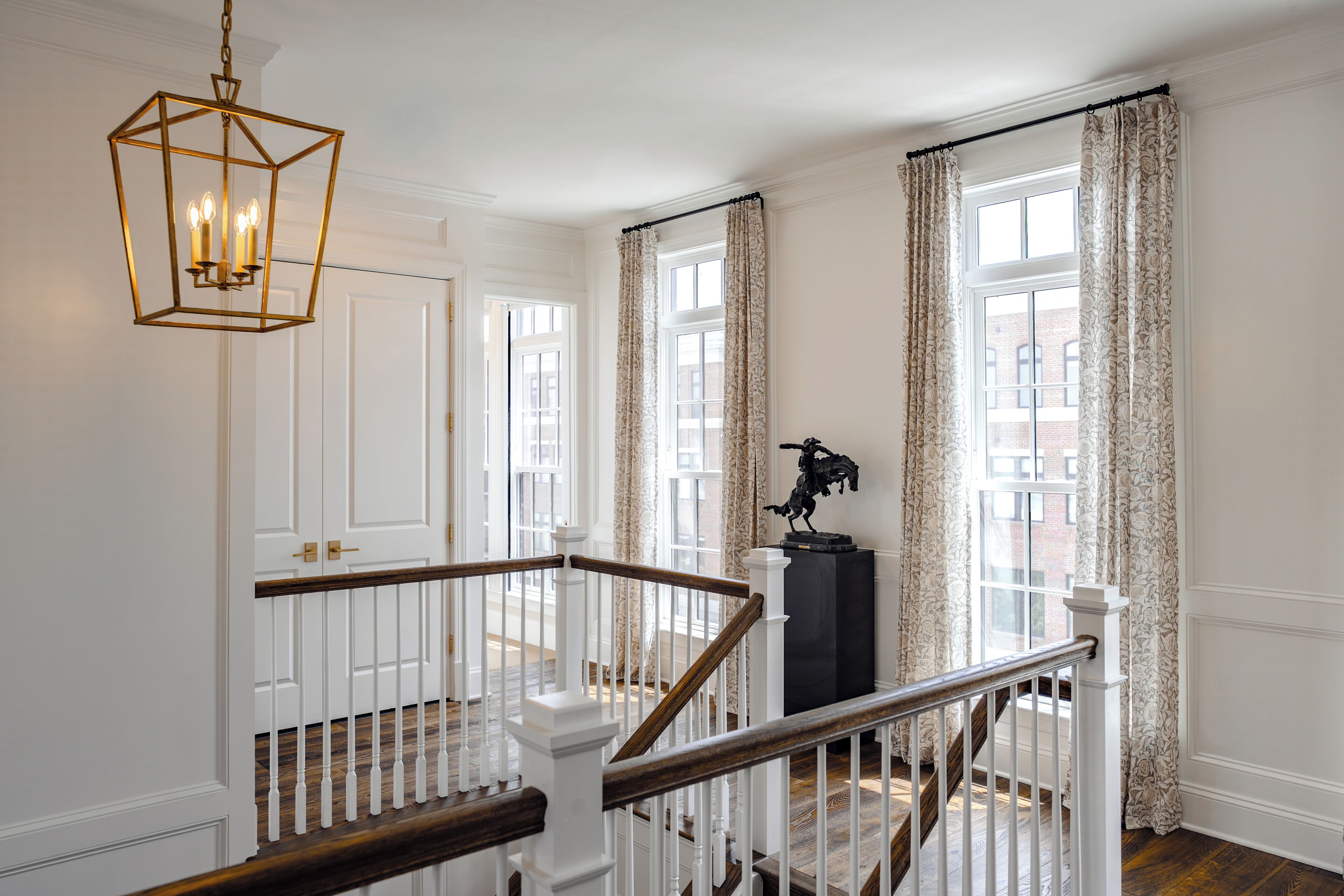A staircase with white railings and wooden steps leading to a landing.