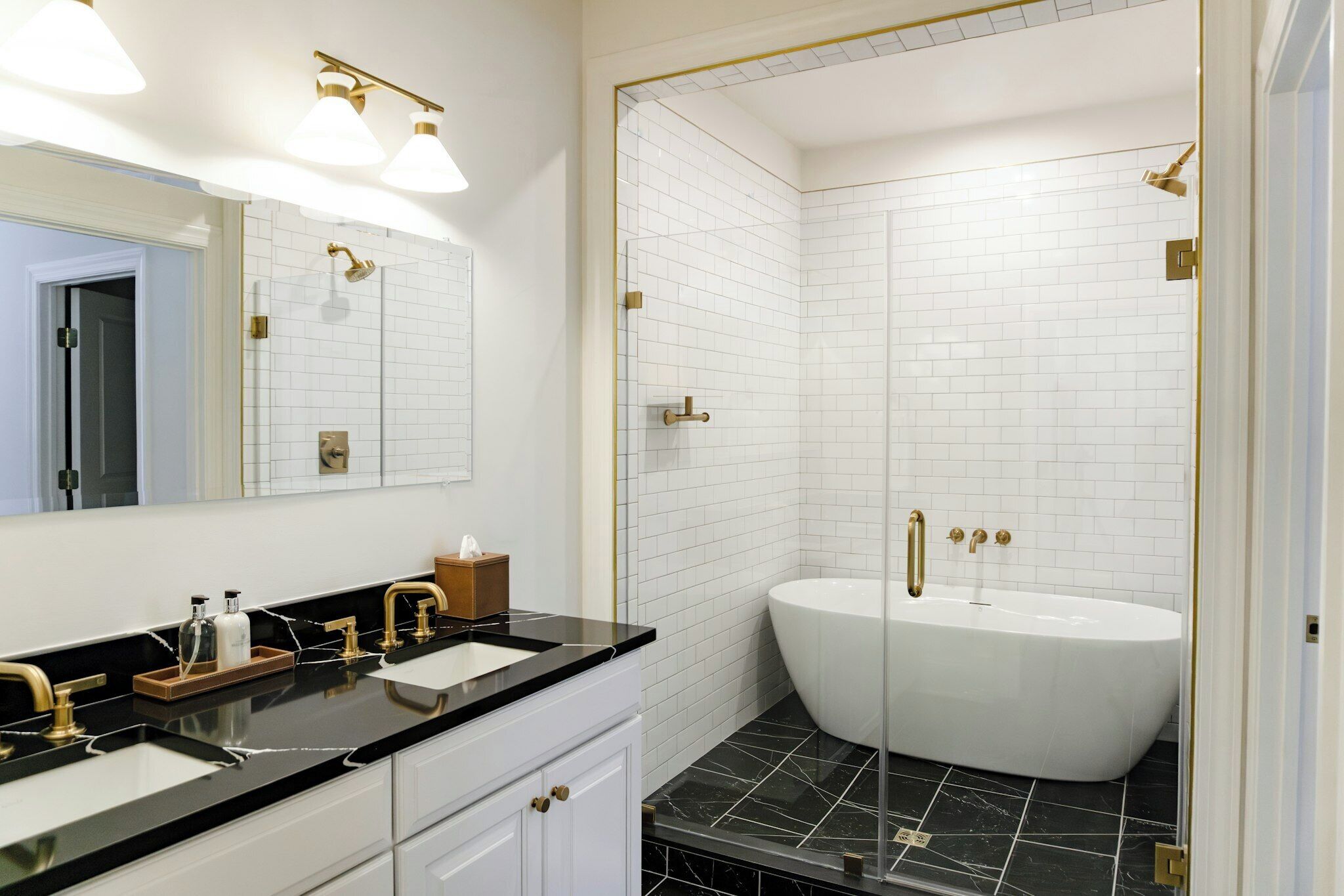 A modern bathroom with a freestanding bathtub, a double sink vanity, and a large mirror.