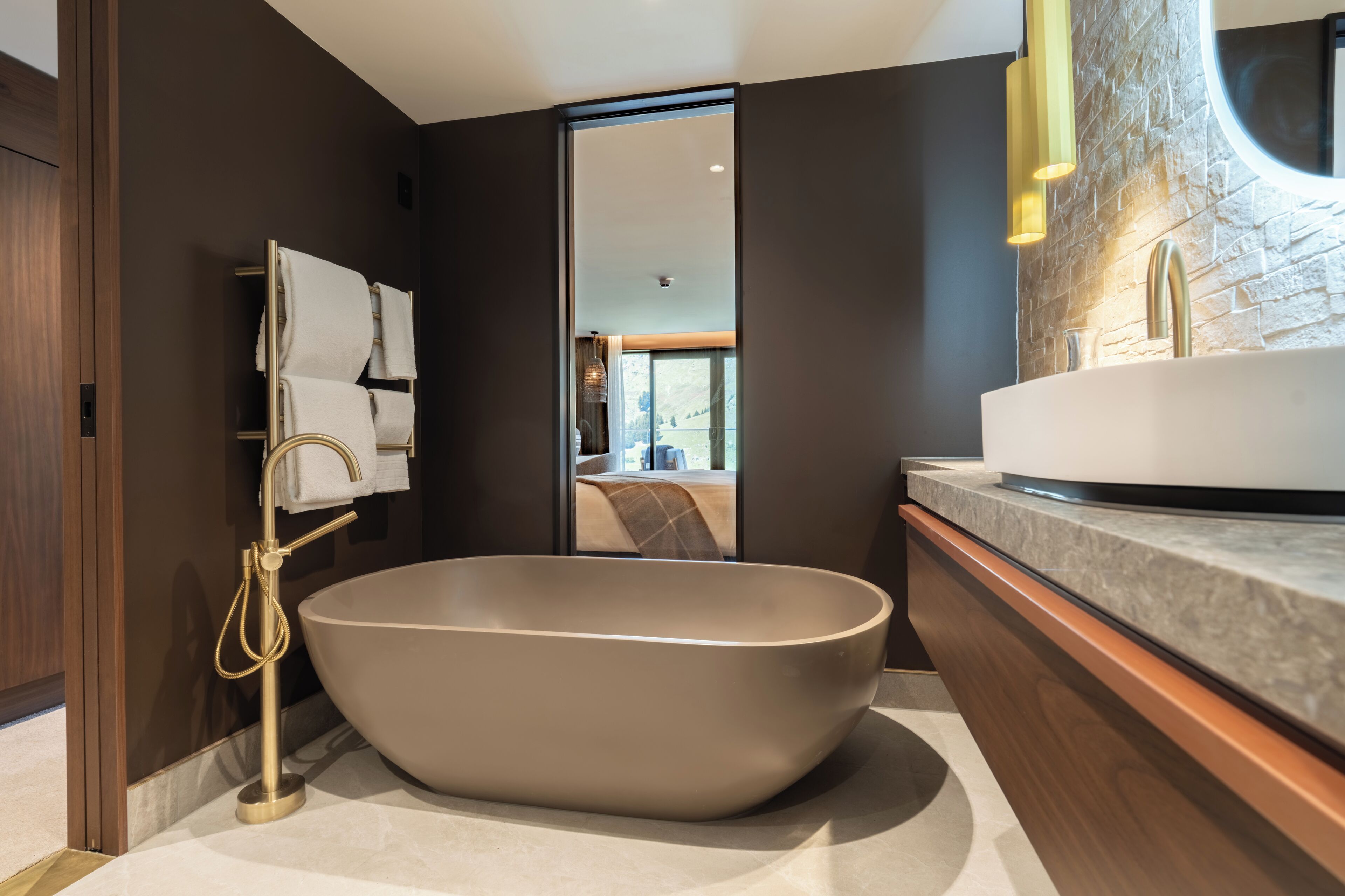 A modern bathroom with a freestanding bathtub, a vanity with a sink, and a mirror.