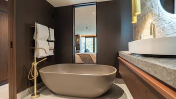 A modern bathroom with a freestanding bathtub, a vanity with a sink, and a mirror.