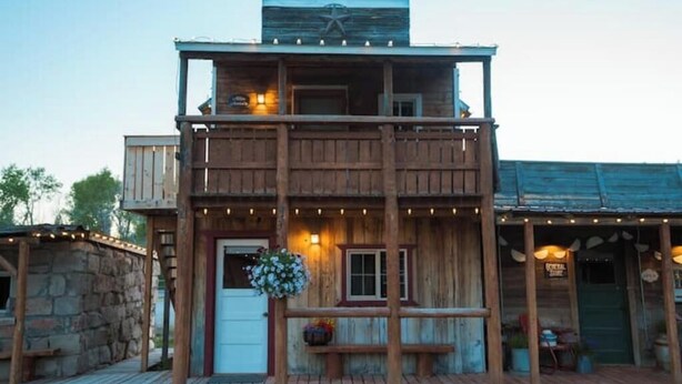 Un bâtiment en bois à deux étages, doté d’un balcon, de guirlandes lumineuses et d’une enseigne sur laquelle on peut lire « Social Club ».