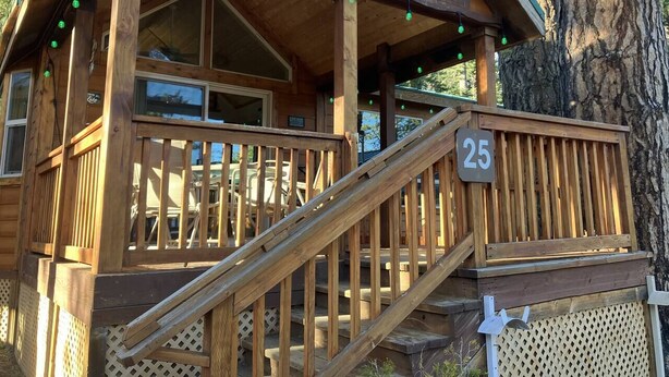 Eine Holzhütte mit Balkon, einer Treppe und einem Schild mit der Nummer 25.