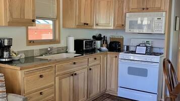 Een kookplaat, kookgerei, borden en bestek