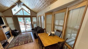 A cozy cabin interior with a wooden dining table, chairs, a sofa, and a fireplace. - Cabin #18 at Hyatt Lake Resort (Jackson County)