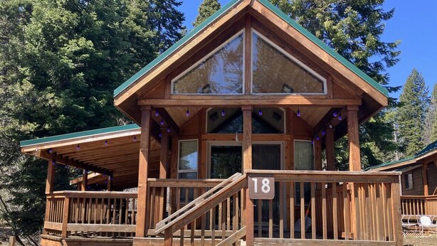 A wooden cabin with a balcony, a staircase, and a number '18' sign. - Cabin #18 at Hyatt Lake Resort (Jackson County)