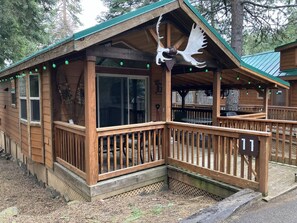 Une cabane en bois avec un porche, une grande sculpture d’oiseau et une enseigne portant le chiffre « 11 ».