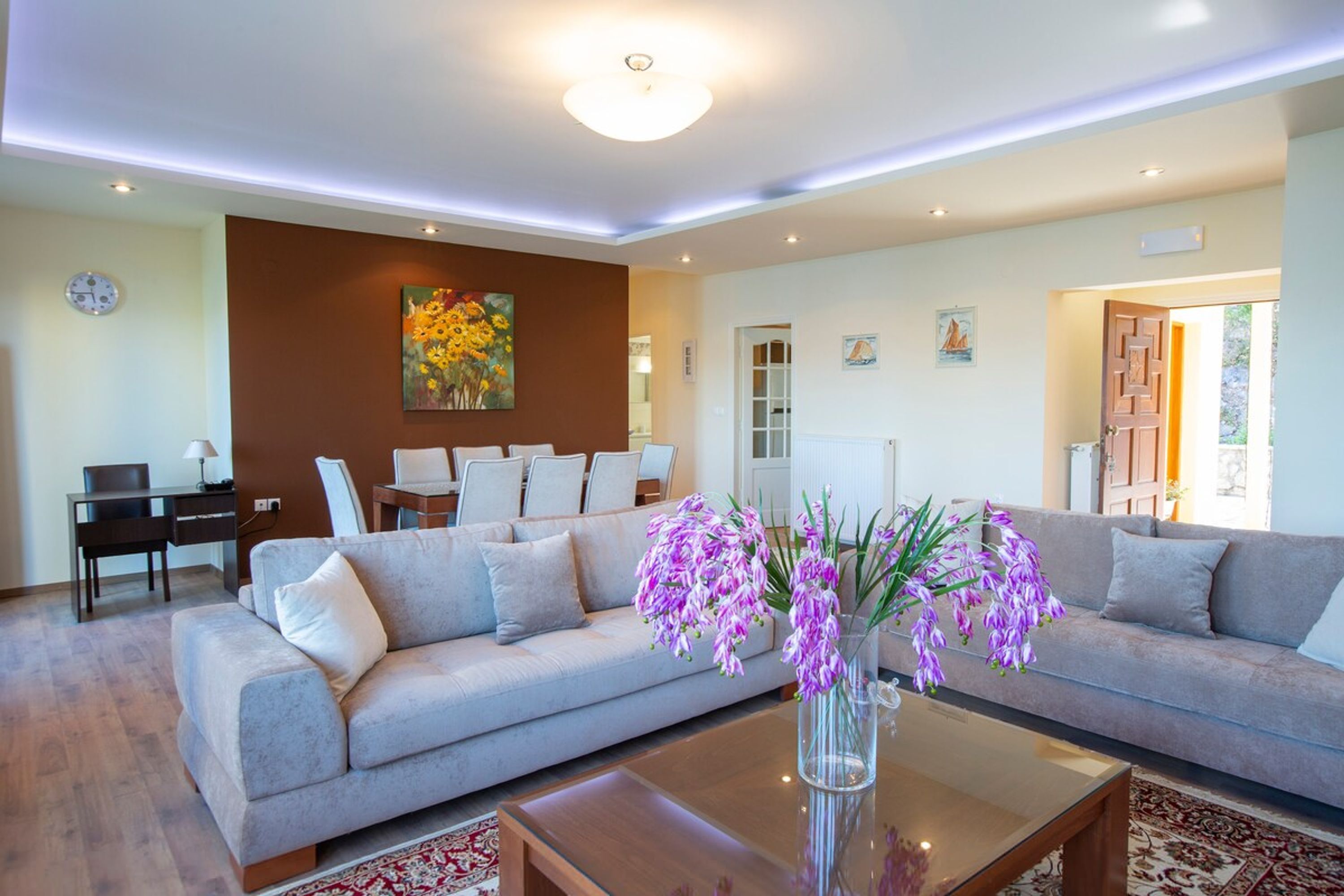 A modern living room with a sofa, coffee table, and a vase of flowers.