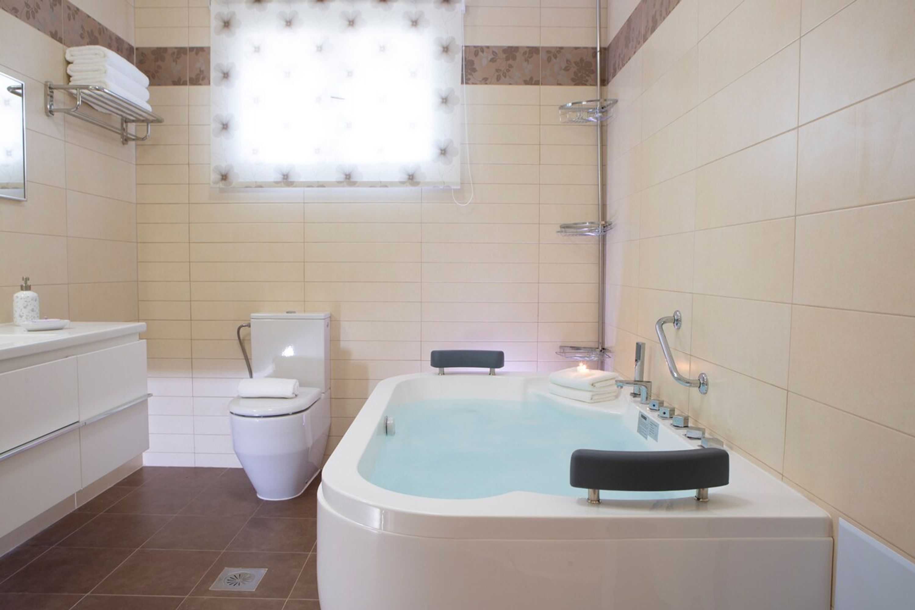 A modern bathroom with a bathtub, toilet, and vanity.