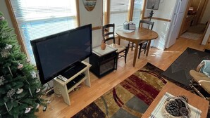 Una sala moderna con un televisor de pantalla plana, una mesa de comedor y un árbol de Navidad.