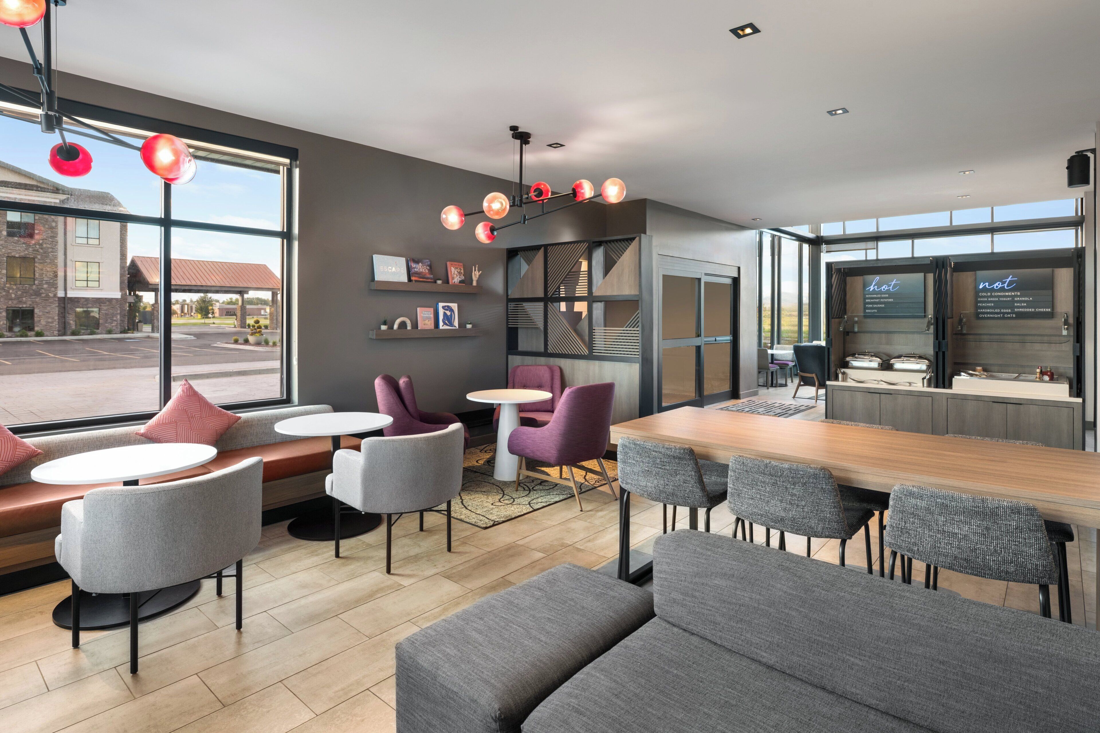 L’intérieur d’un café moderne, avec des tables et des chaises, un comptoir et un présentoir pour afficher le menu.
