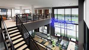 A spacious, multi-level hotel lobby with a staircase, seating areas, and large windows offering views of the street. - Atwell Suites Belgrade Bozeman Airport by IHG (Belgrade)