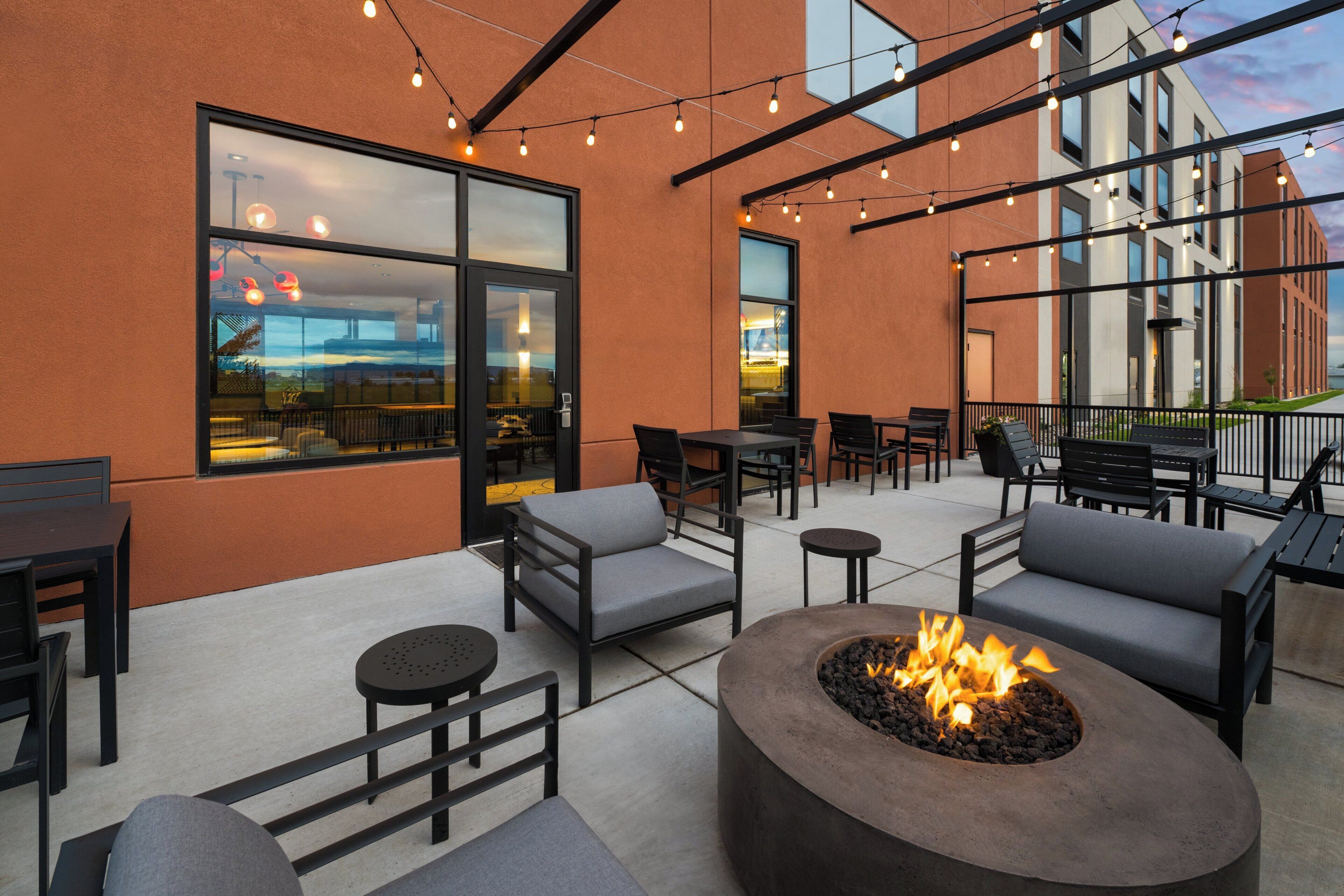 An outdoor seating area with tables, chairs, and a fire pit.