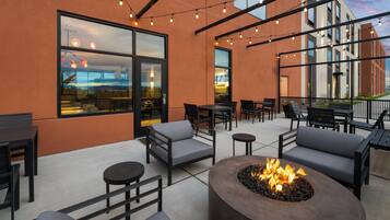 An outdoor seating area with tables, chairs, and a fire pit.