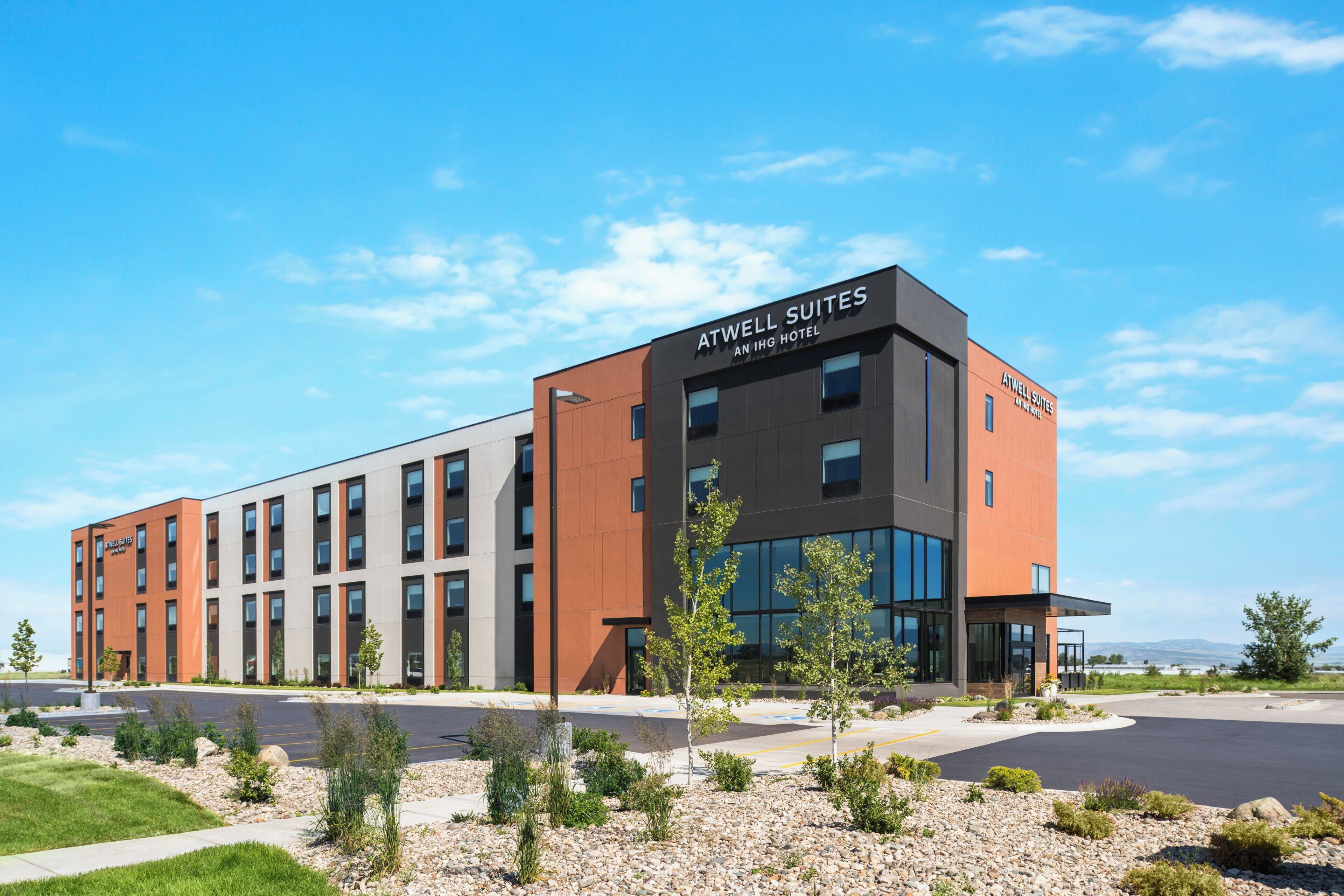 En moderne hotelbygning med et skilt, der viser 'Atwell Suites' og 'An IHG Hotel'.