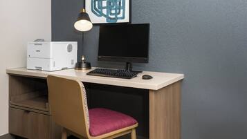 A modern office desk with a computer, a printer, and a chair.