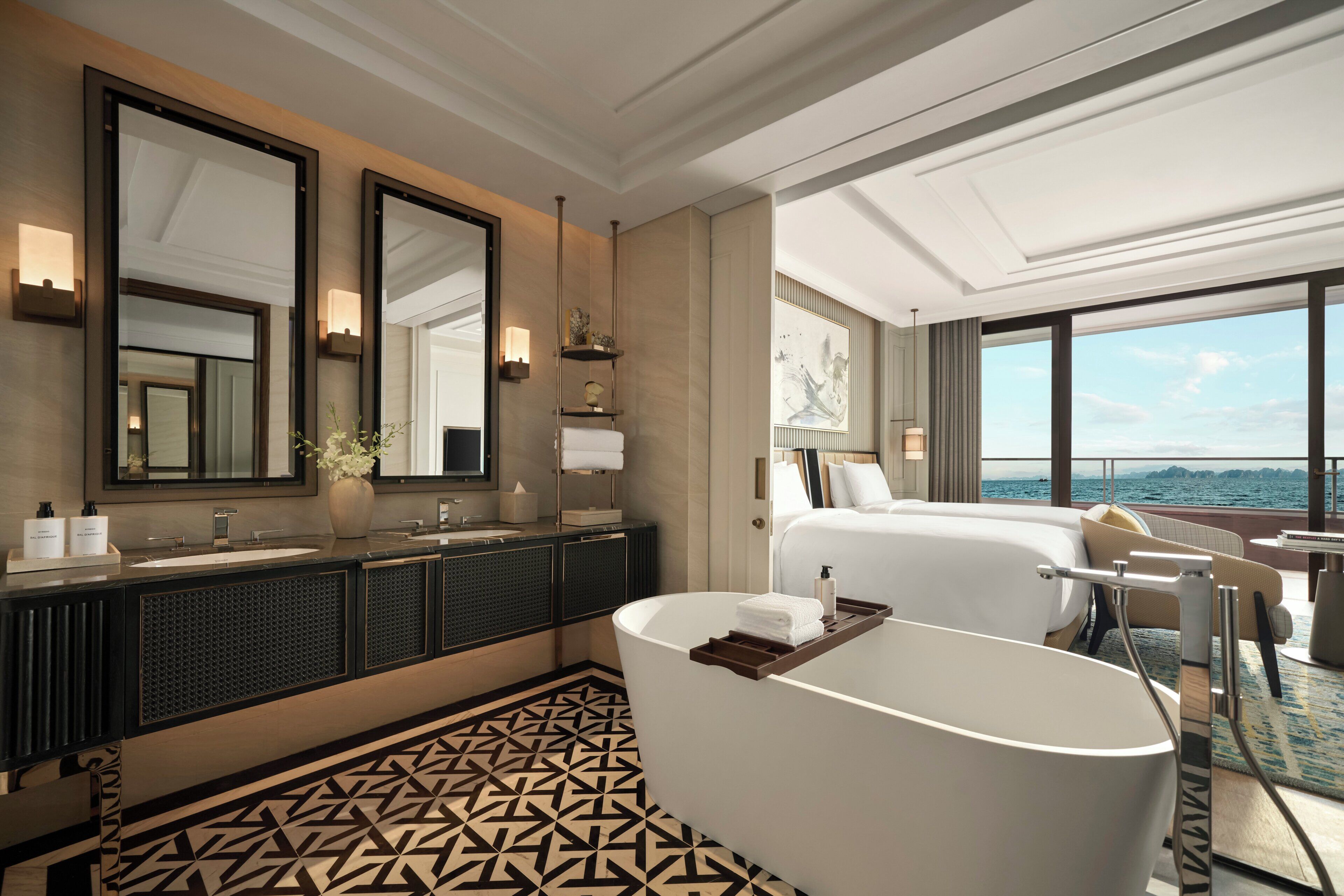 Ein modernes Hotelbad mit einer großen Badewanne, zwei Waschbecken und einem großen Spiegel.