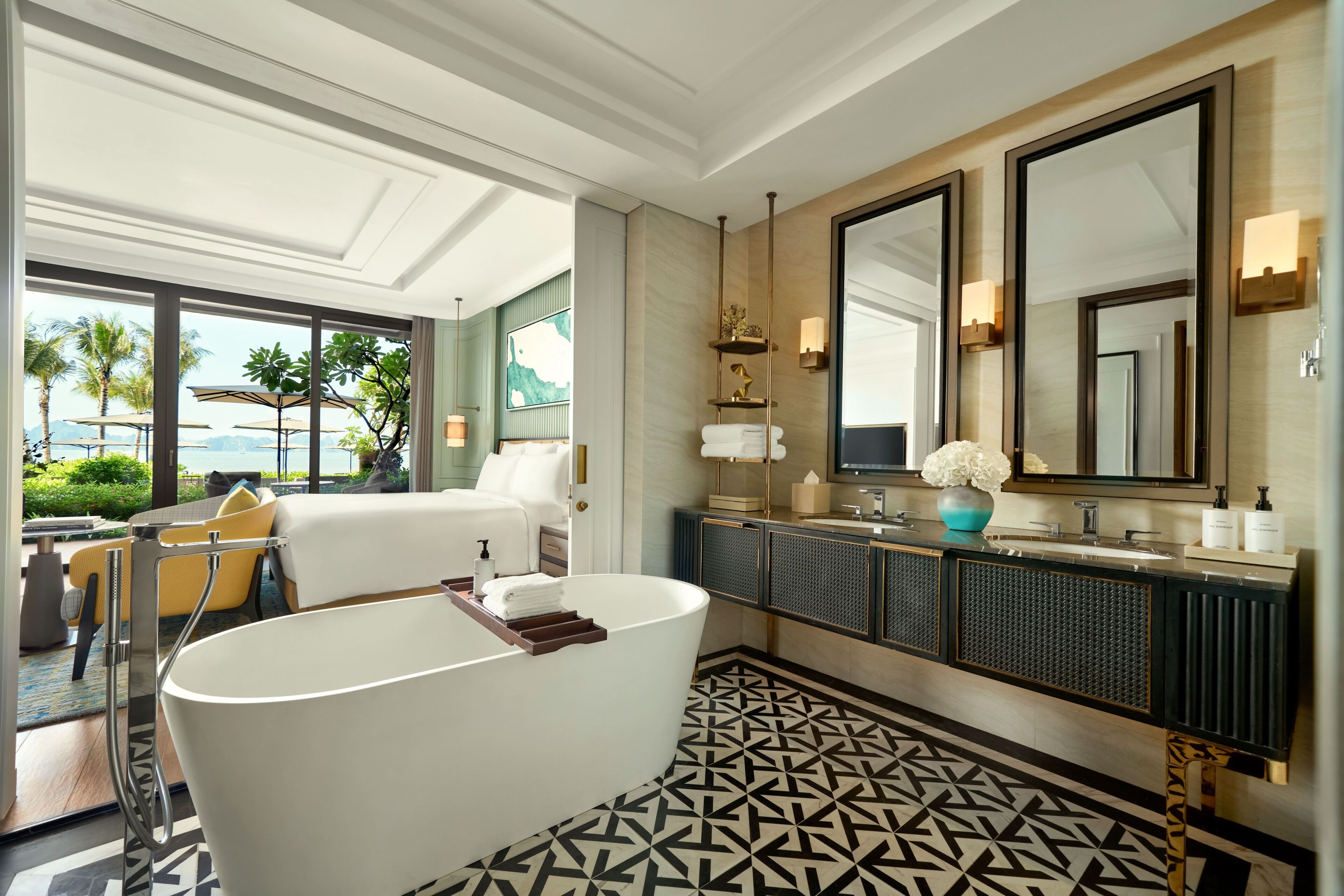 A modern bathroom with a large bathtub, a vanity with a mirror, and a view of the outdoors.