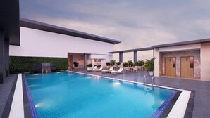 Zona de piscina interior moderna con sillones de descanso y una pequeña cascada.