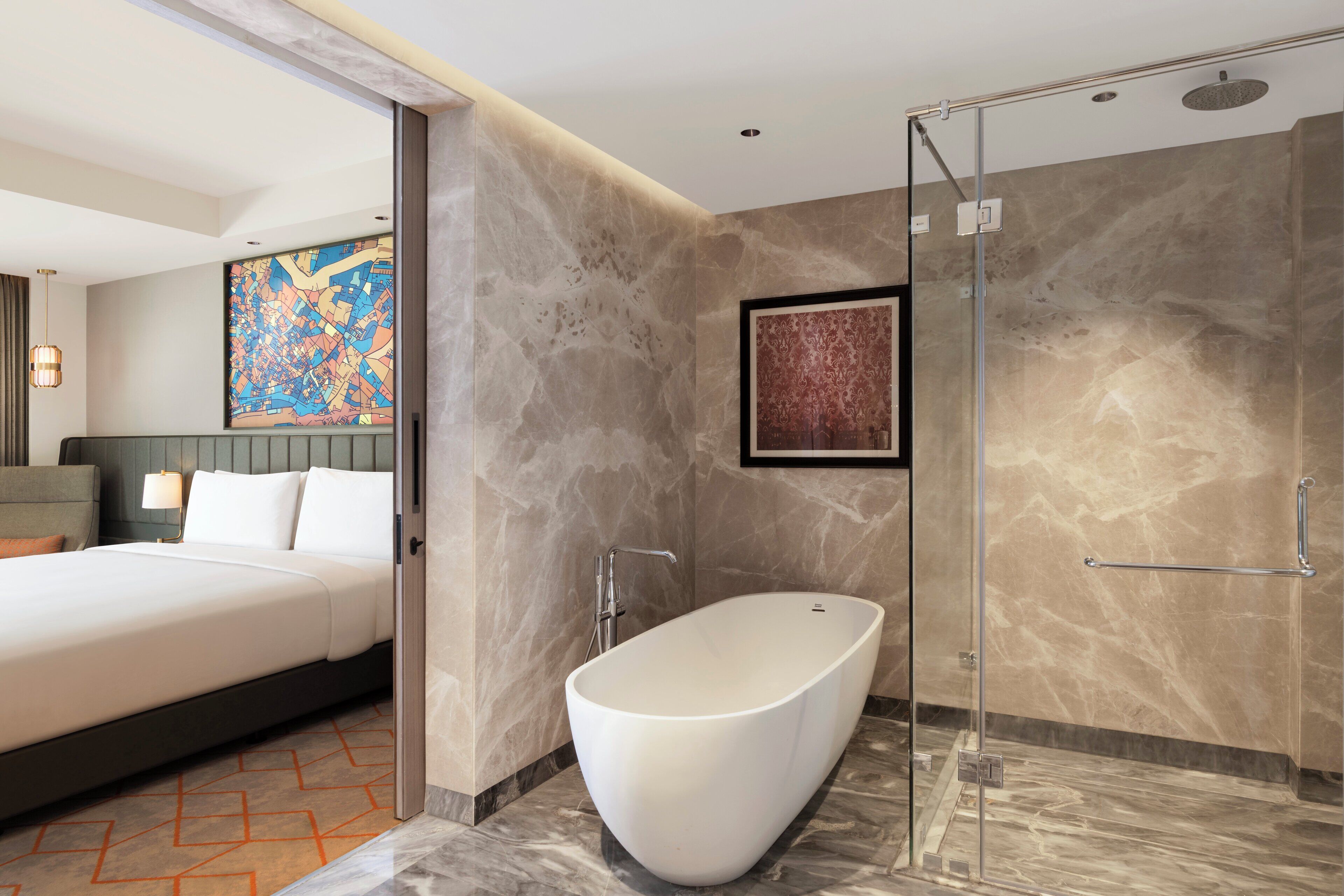 Une chambre d’hôtel moderne dotée d’un grand lit, d’une baignoire sur pieds et d’un espace douche.