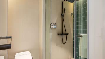 Ein modernes Badezimmer mit Duschkabine aus Glas, Toilette und Waschbecken.