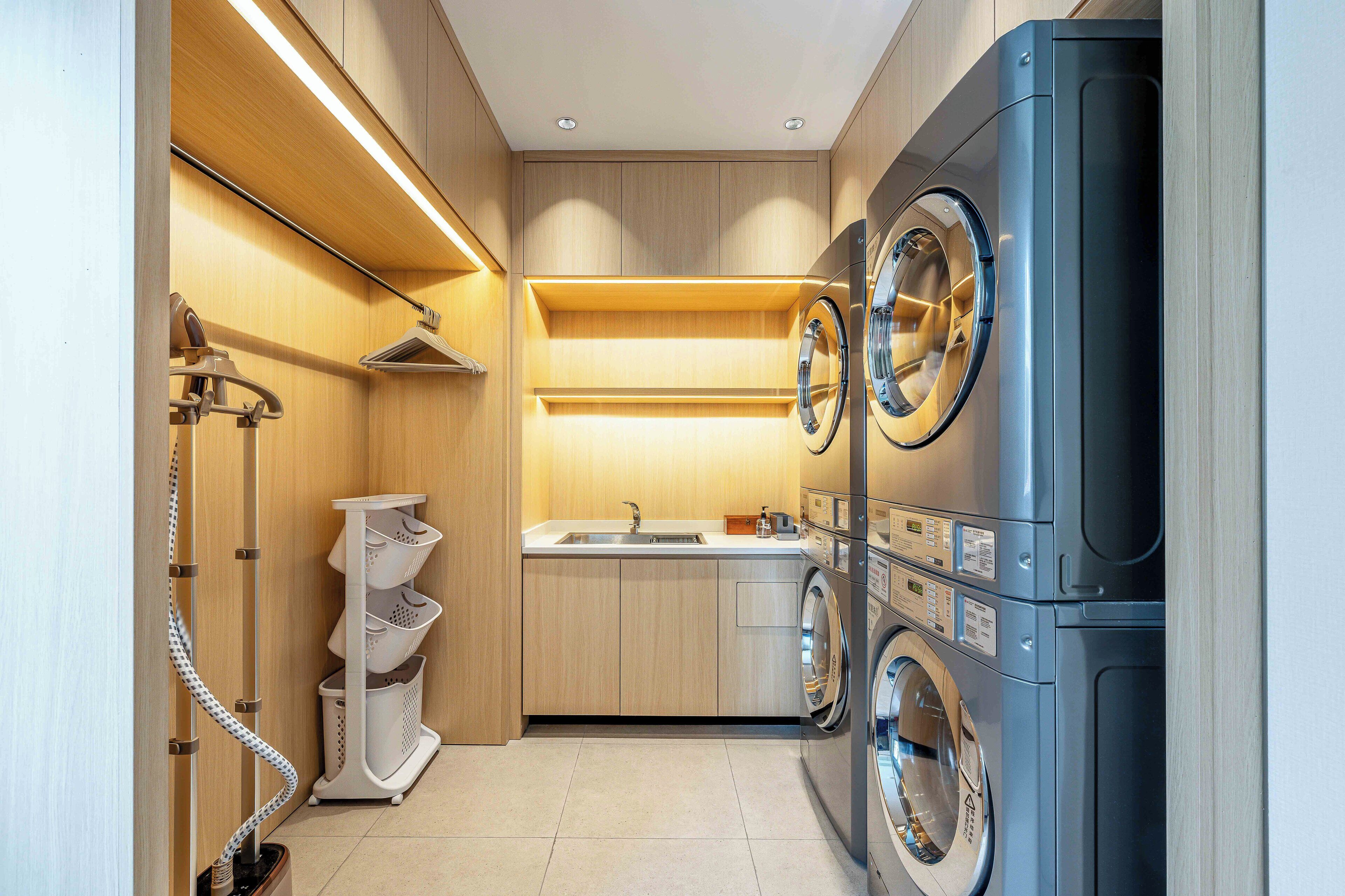 A compact laundry room with a washing machine, dryer, and a small sink.