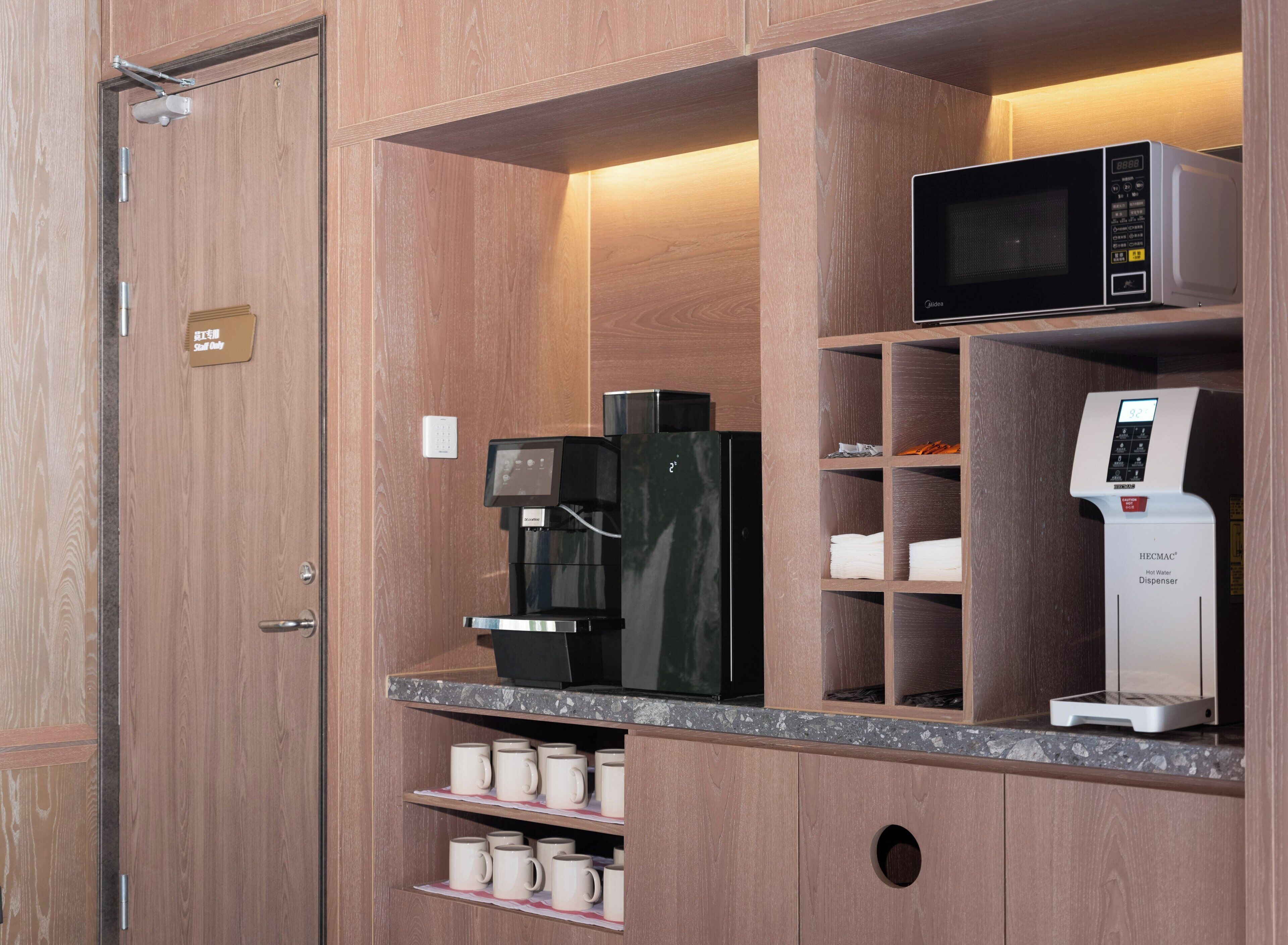A kitchenette with a coffee machine, a microwave, and a hot water dispenser.