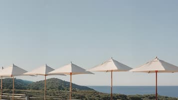 Een buitenzwembad, parasols voor strand/zwembad