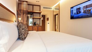 A hotel room with a bed, a TV mounted on the wall, and a wooden cabinet. - Hotel Indigo Gandia Beach by IHG (Gandia)