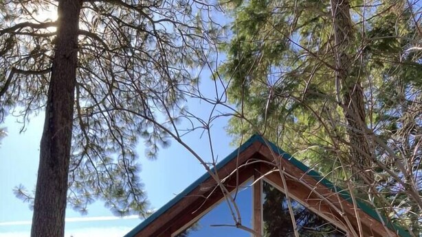 A wooden cabin with a balcony and a staircase leading to the entrance. - Cabin #2 at Hyatt Lake Resort (Jackson County)