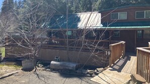 Une cabane dotée d’une terrasse en bois, d’un petit porche et d’une plaque portant le numéro « 19 ».