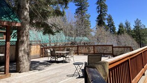 Une terrasse en bois avec des meubles d’extérieur, un vélo et une clôture en bois.