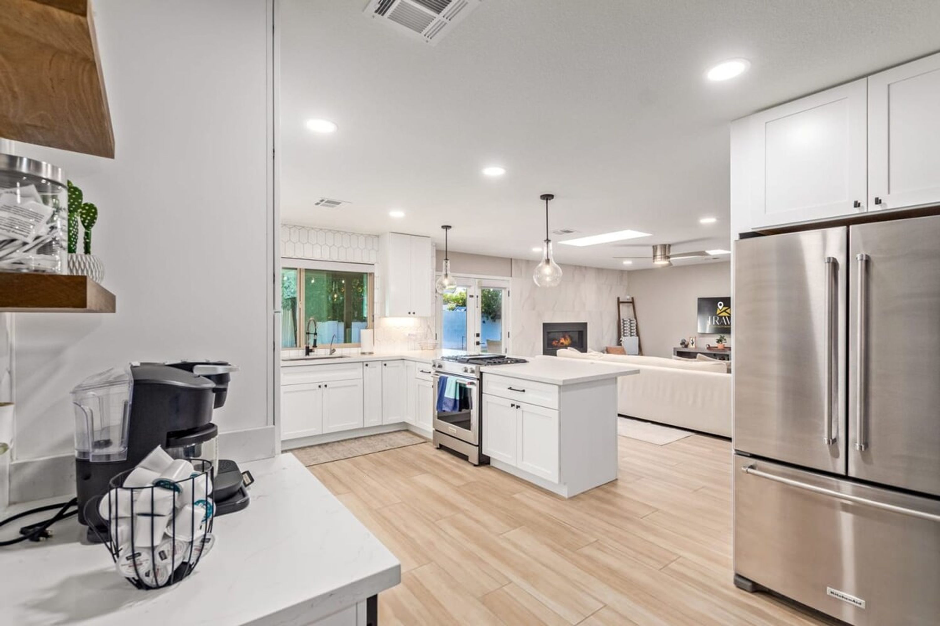 A modern kitchen with white cabinetry, stainless steel appliances, and a central island.